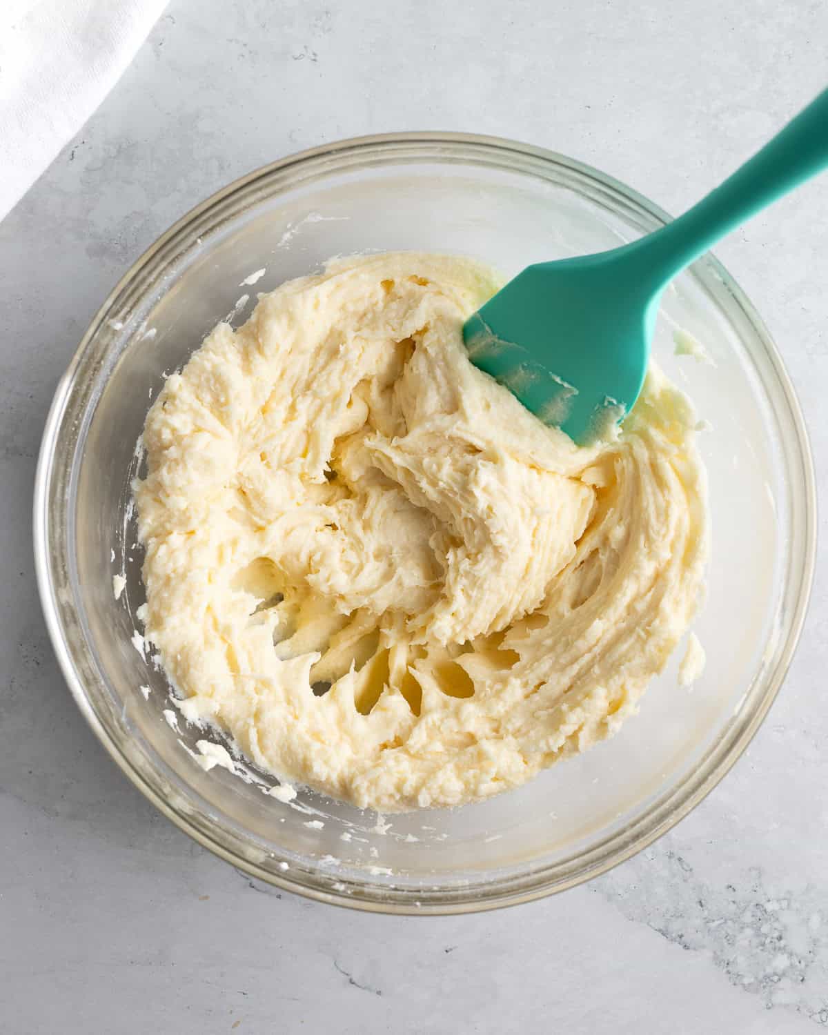 Butter, cream cheese, sugars, and vanilla extract blended together in a bowl.