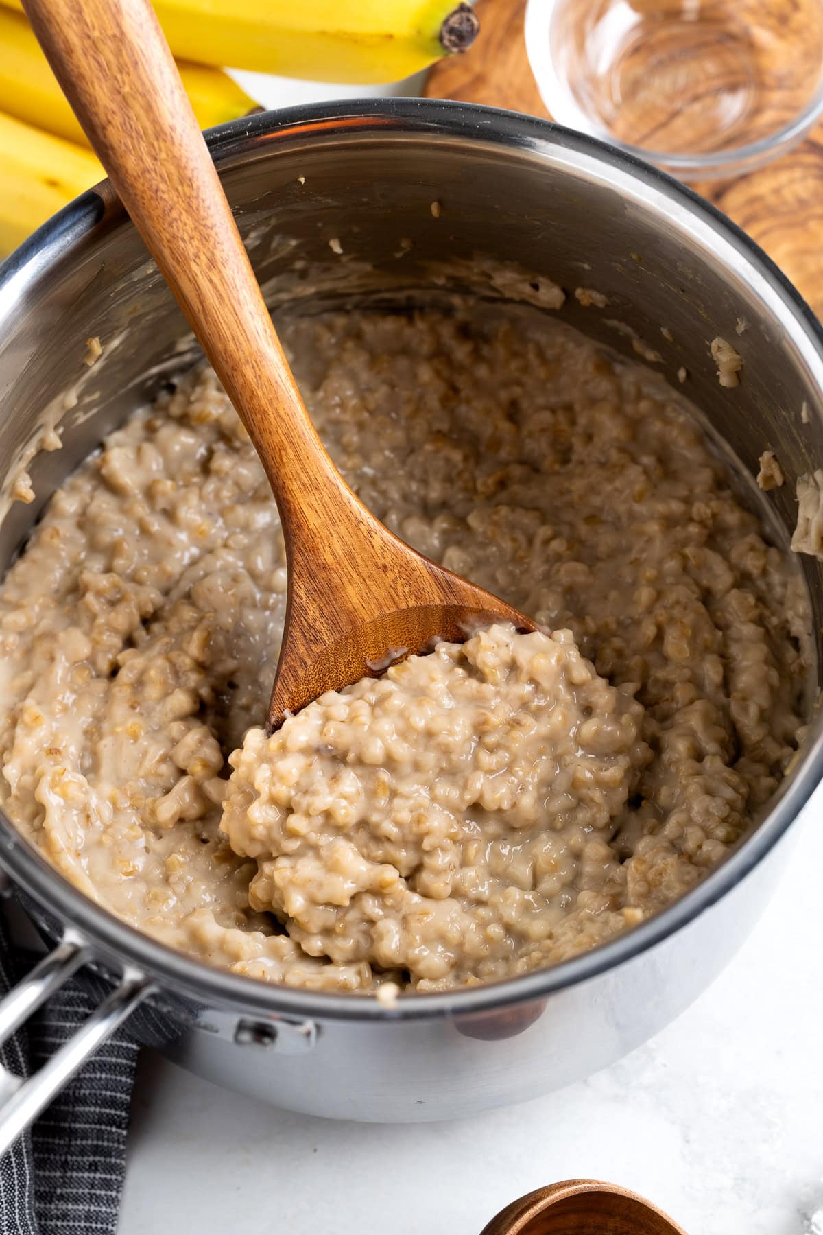 A serving spoon scooping out creamy steel cut oats.