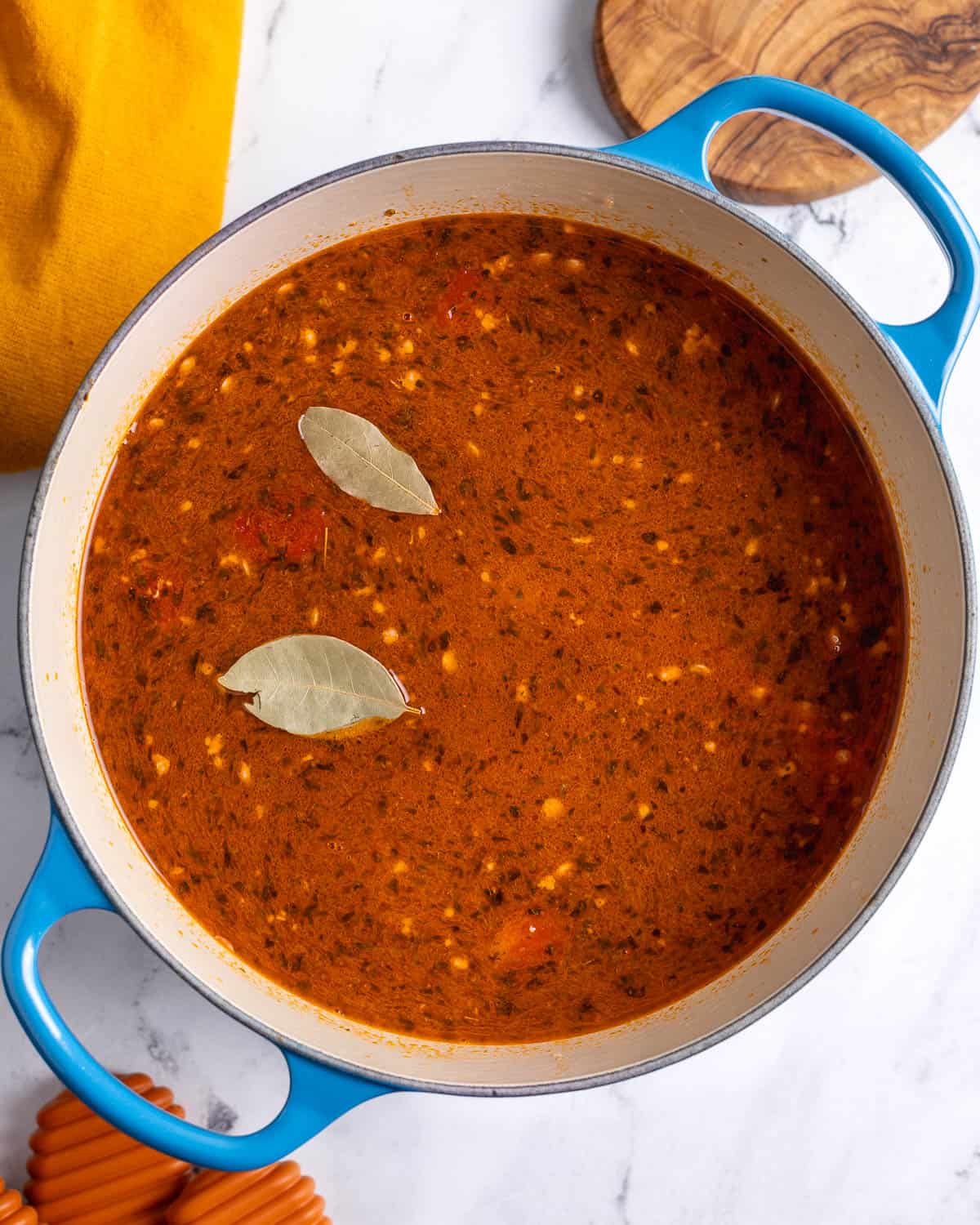 The liquid ingredients and bay leaves added to the pot.
