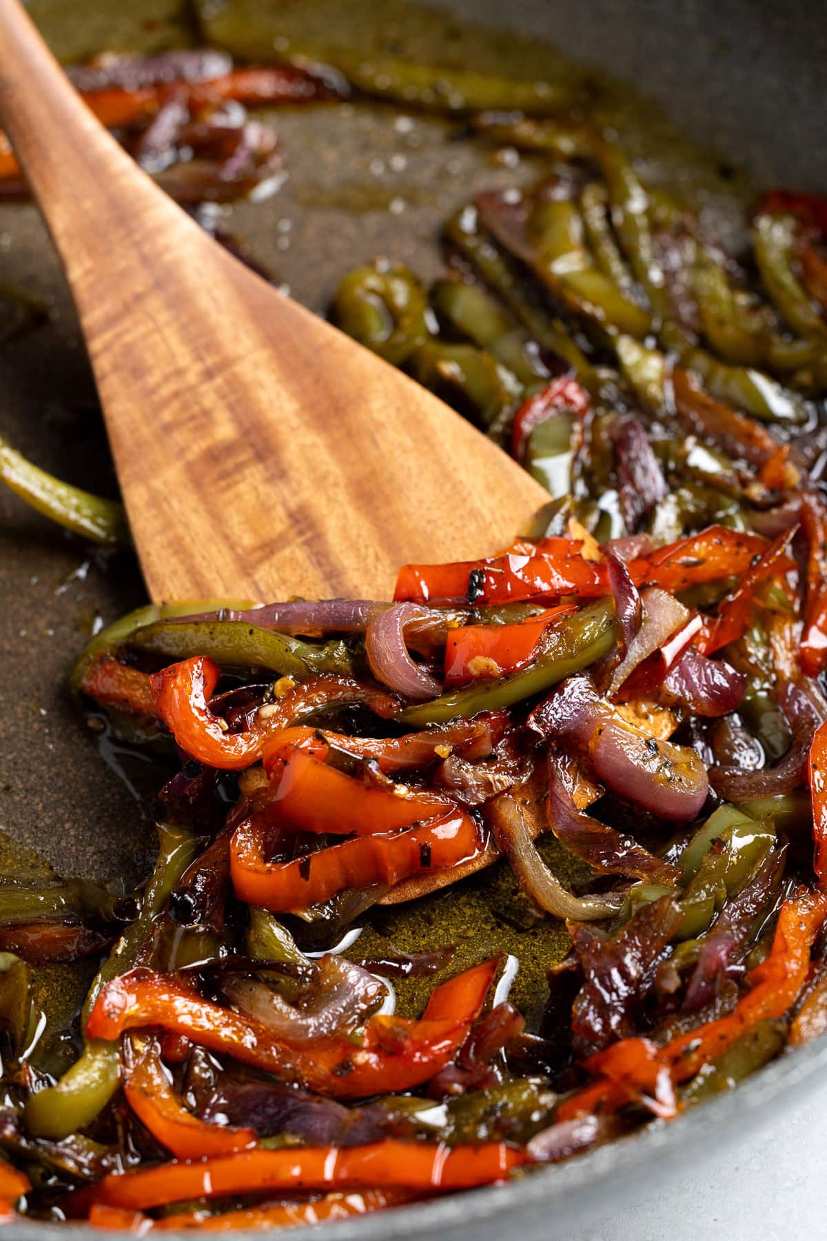 Sautéed Italian peppers and onions in a pan.