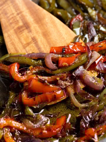 Sautéed Italian peppers and onions in a pan.
