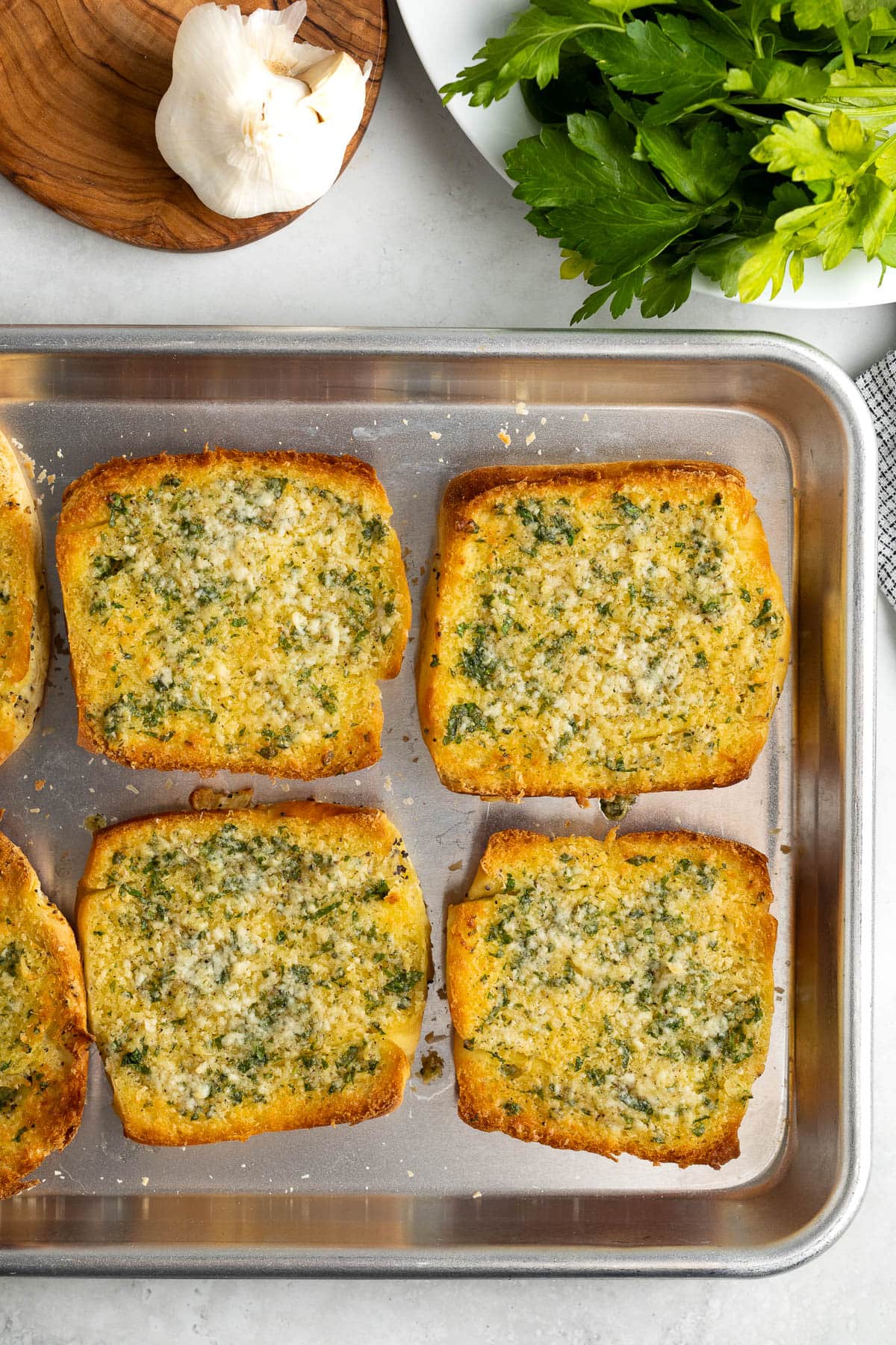 Baked and crisped onion garlic bread on a rimmed sheet pan.
