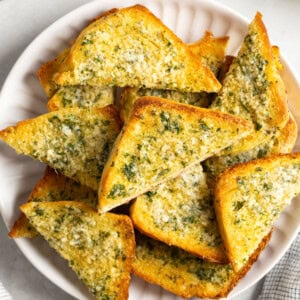 Wedges of sliced onion garlic bread on a plate to serve.