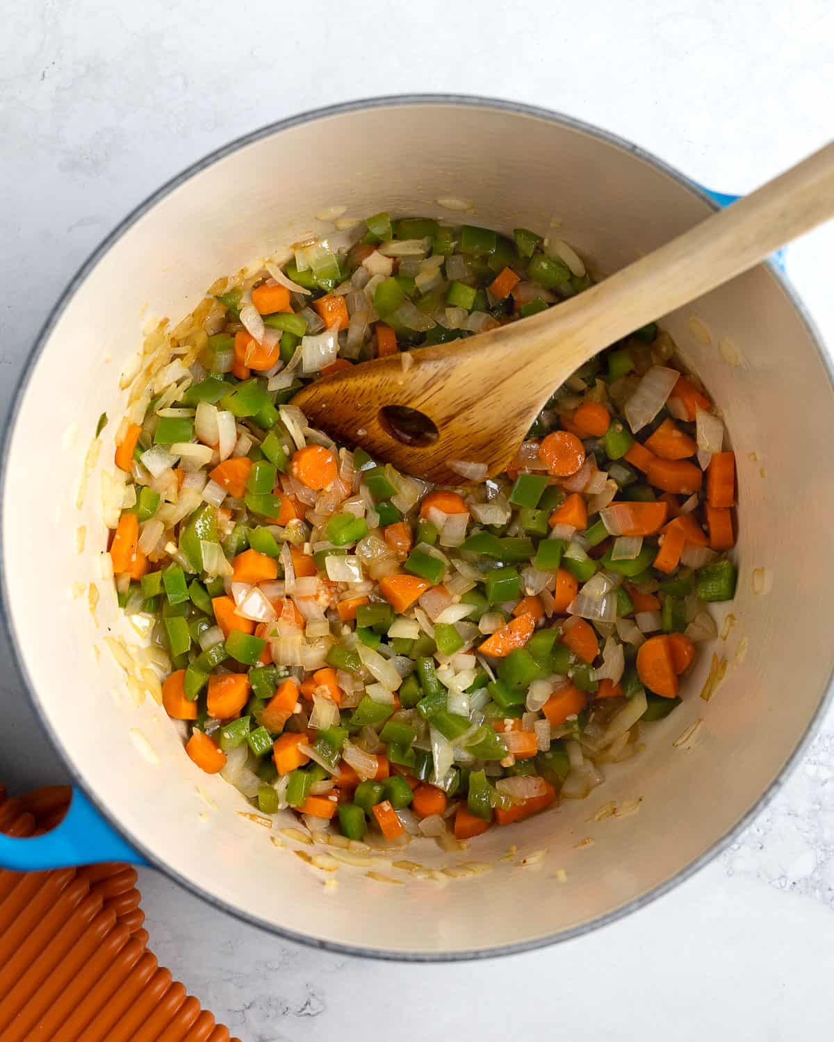 Vegetables sautéed in oil in a large soup pot.