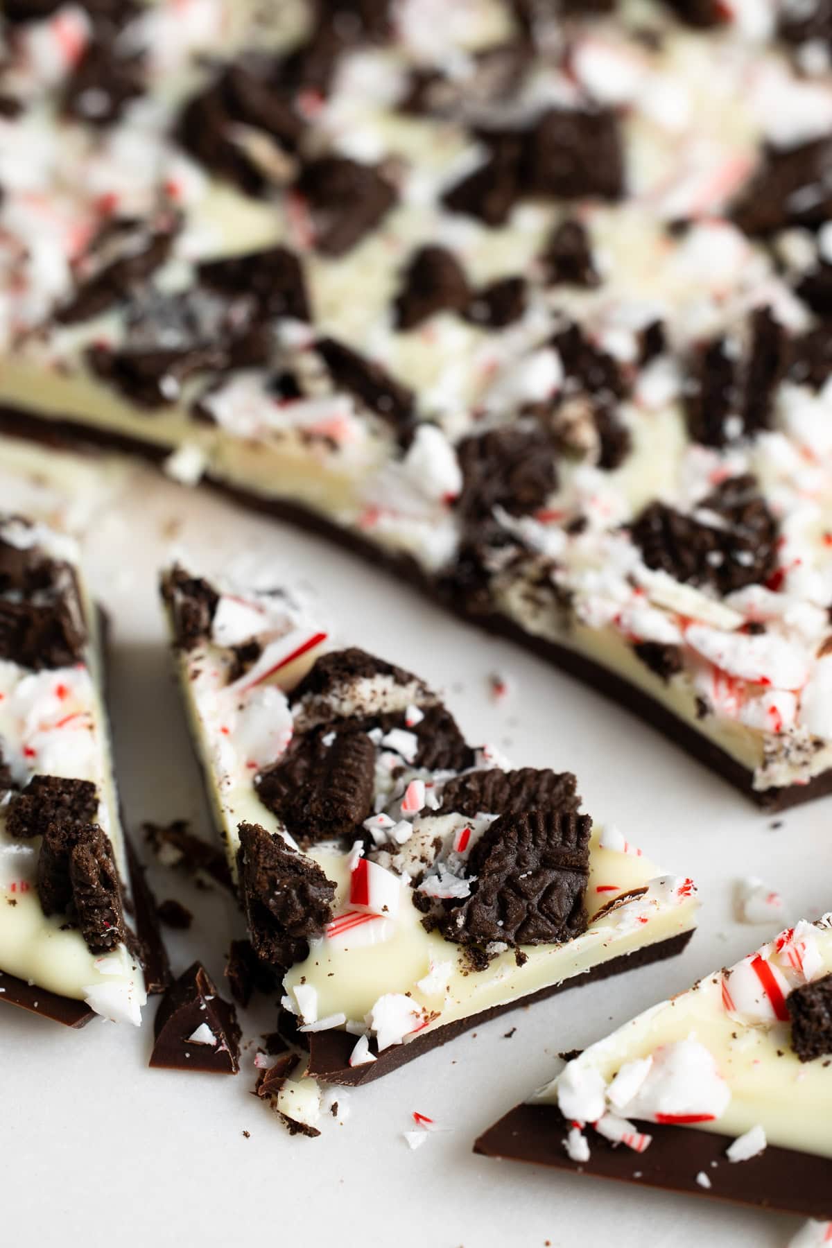 A chopped sliver of the Oreo peppermint bark on a cutting board.