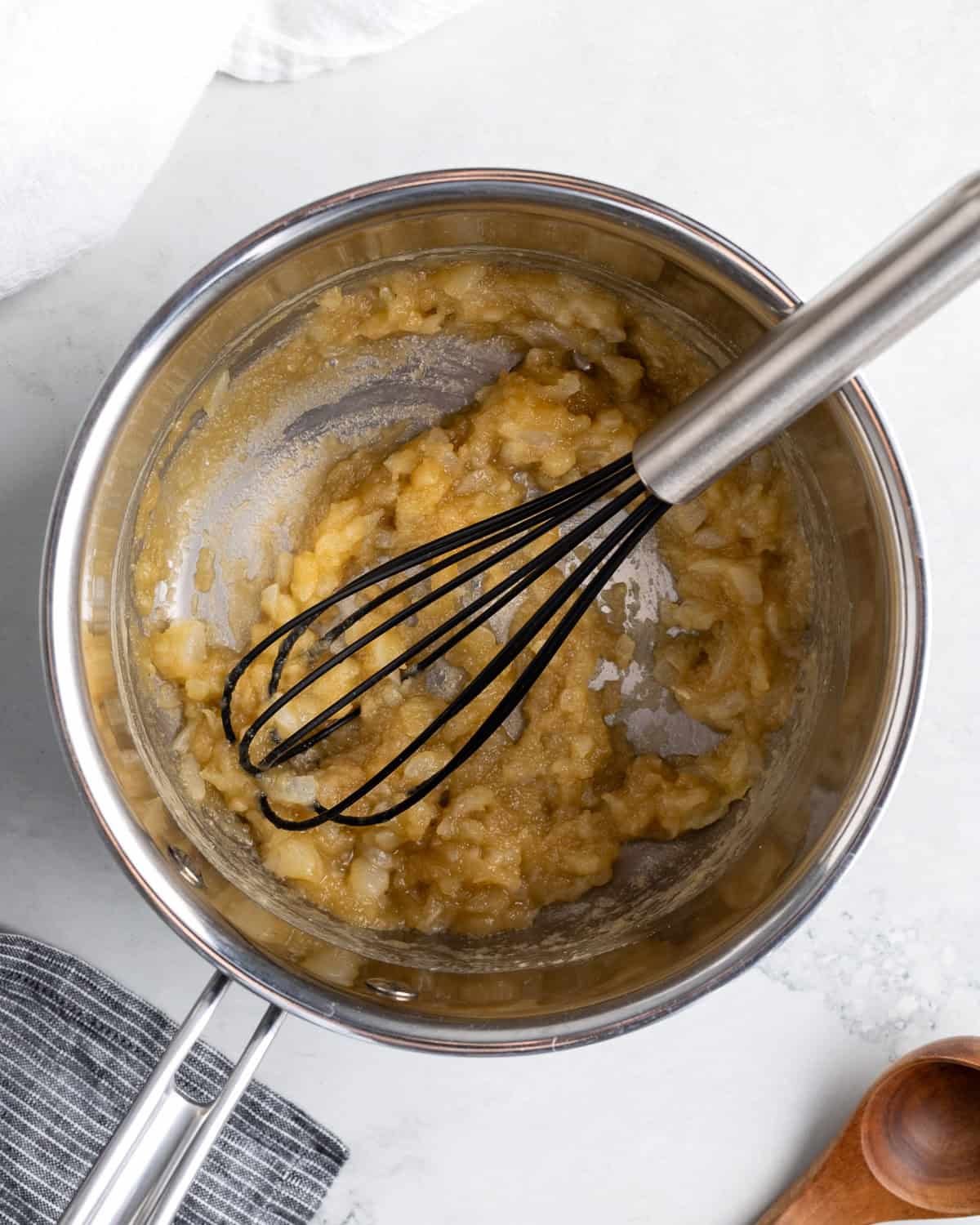 Broth being added to the pan in increments.