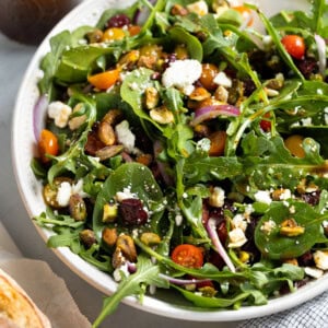 A spinach arugula salad in a serving bowl.