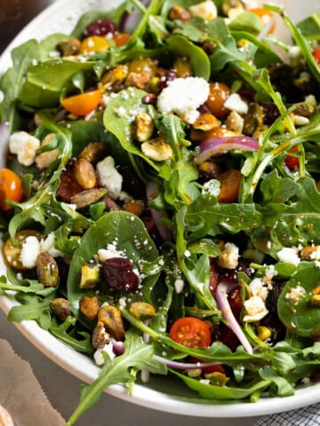 A spinach arugula salad in a serving bowl.