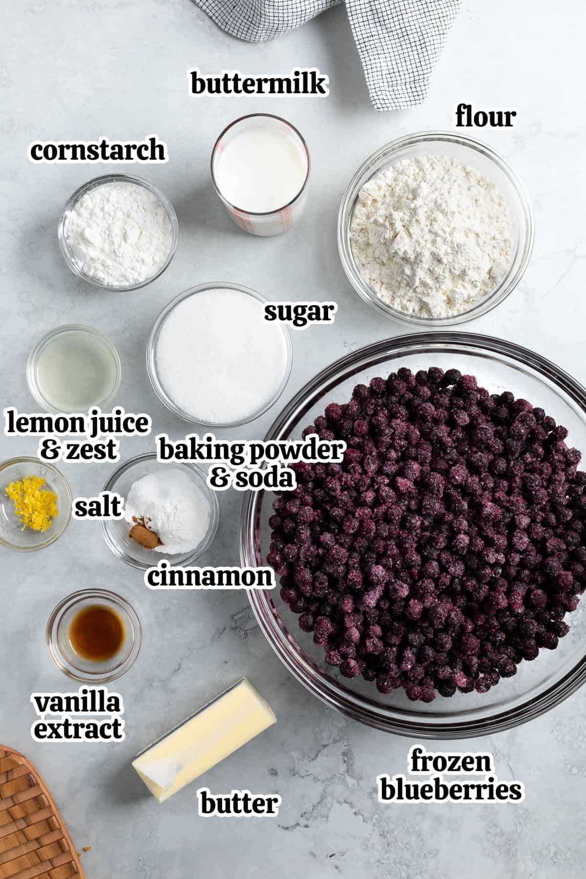 Frozen blueberry cobbler recipe ingredients text-labeled in bowls.
