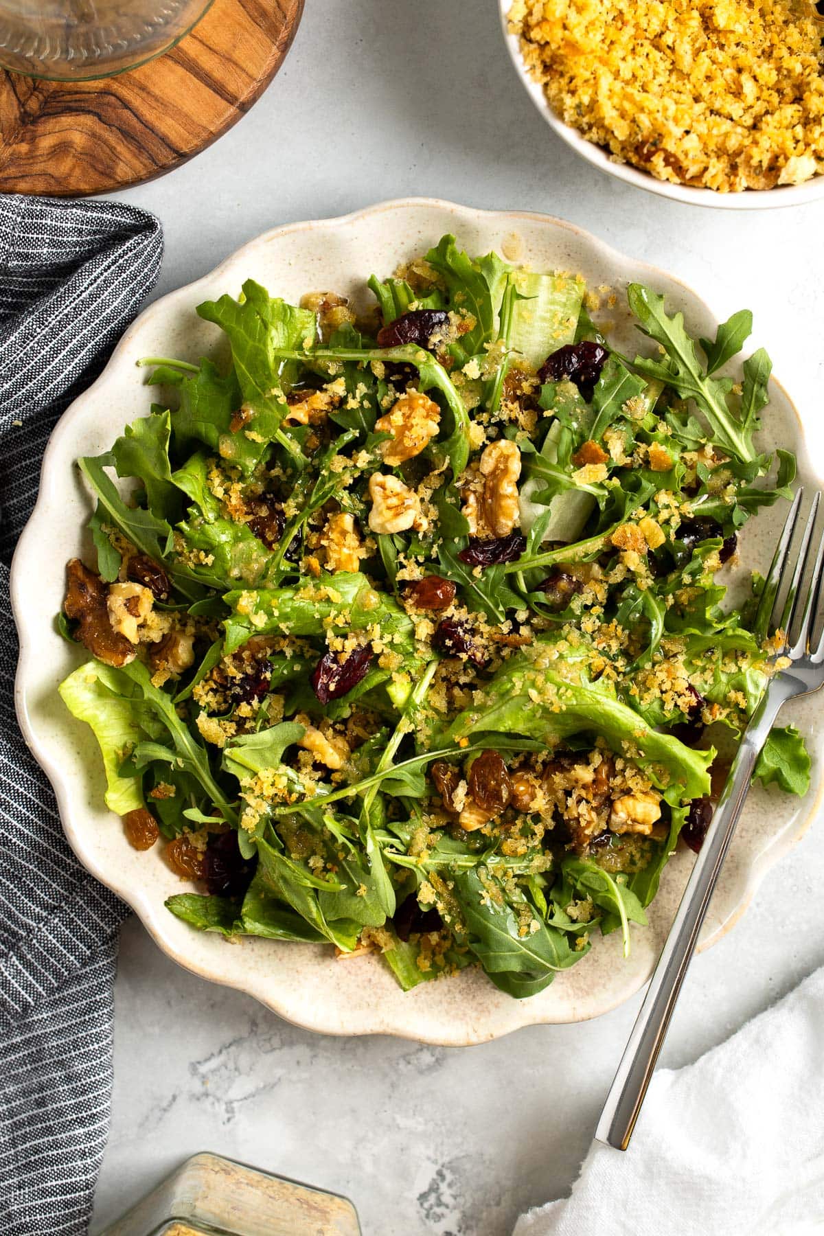 Pangrattato scattered overtop of a mixed greens salad.