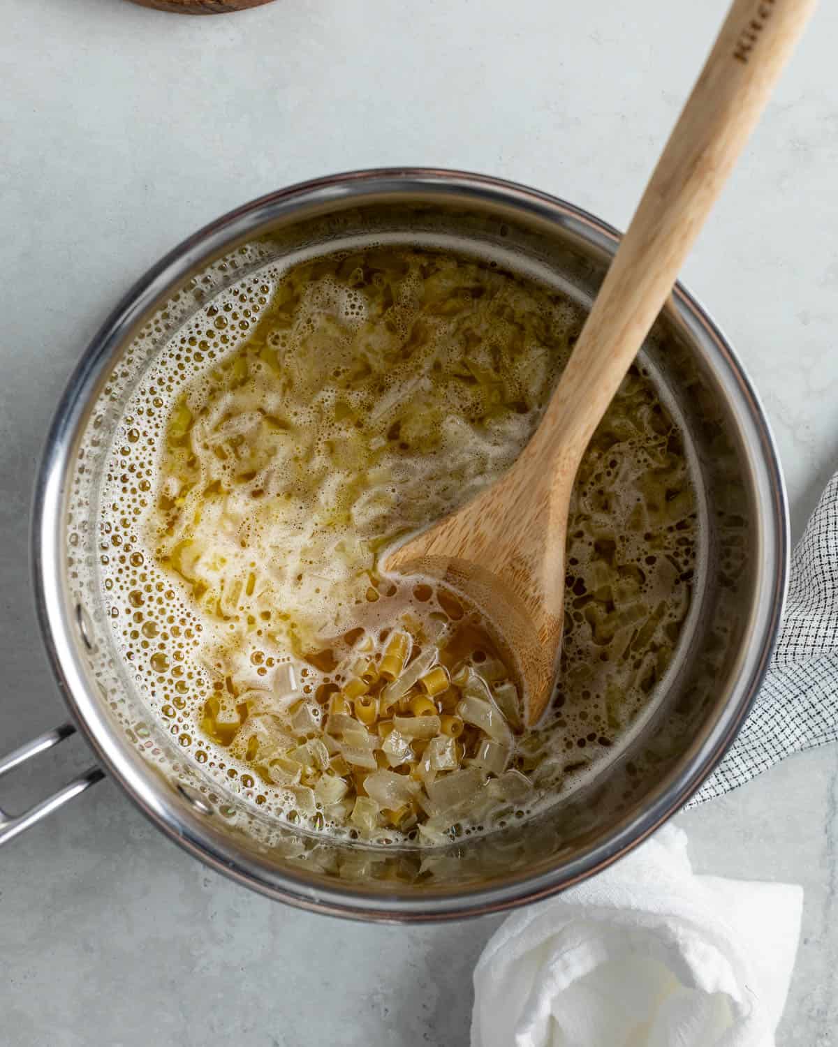 Liquid, pasta, and half of the cheese added to the pot.