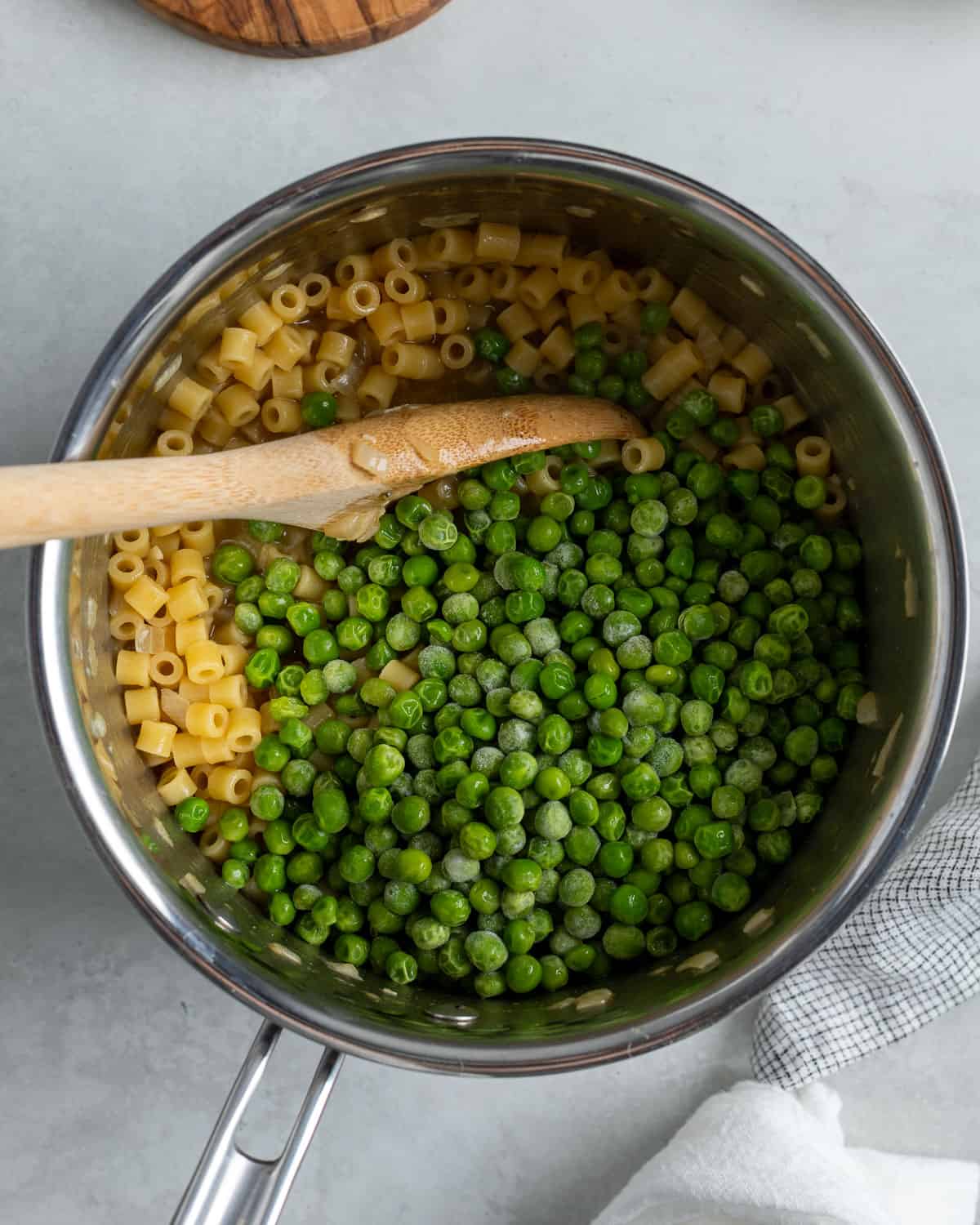 Peas added to the pot of pasta.