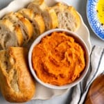 Hot honey butter in a bowl next to a sliced loaf of bread.