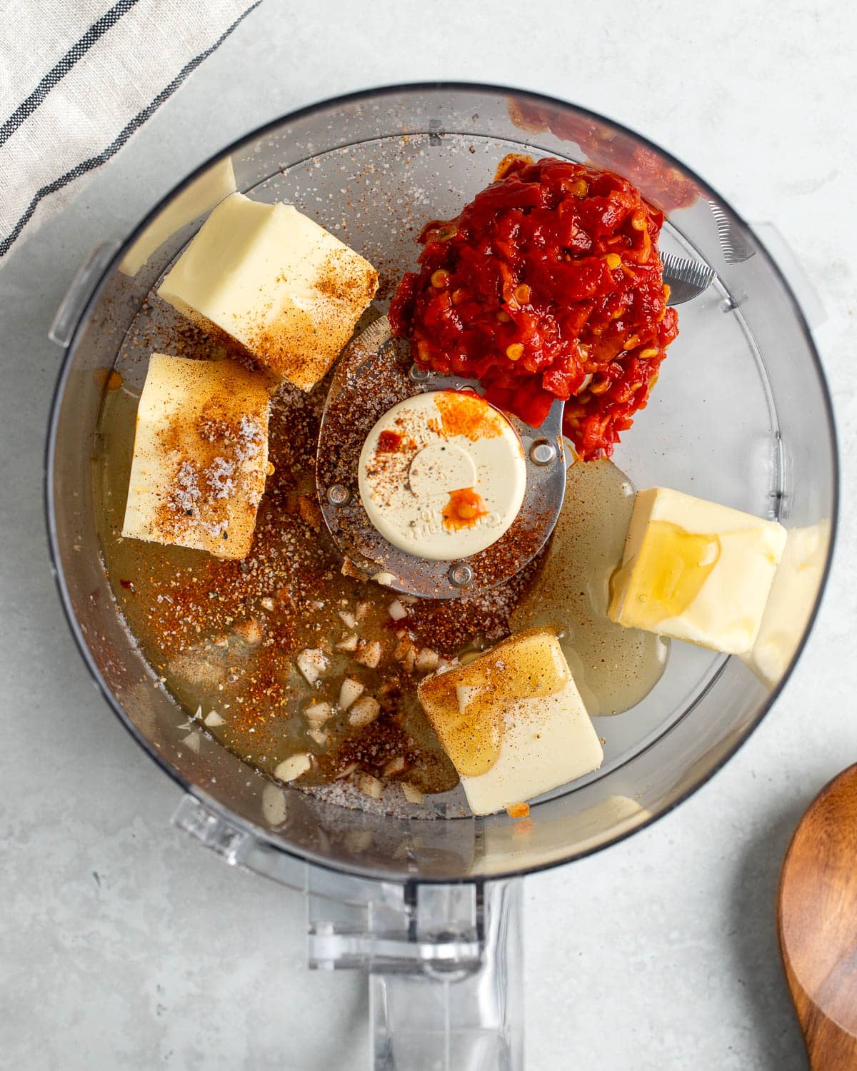 The recipe ingredients added to the bowl of a food processor.