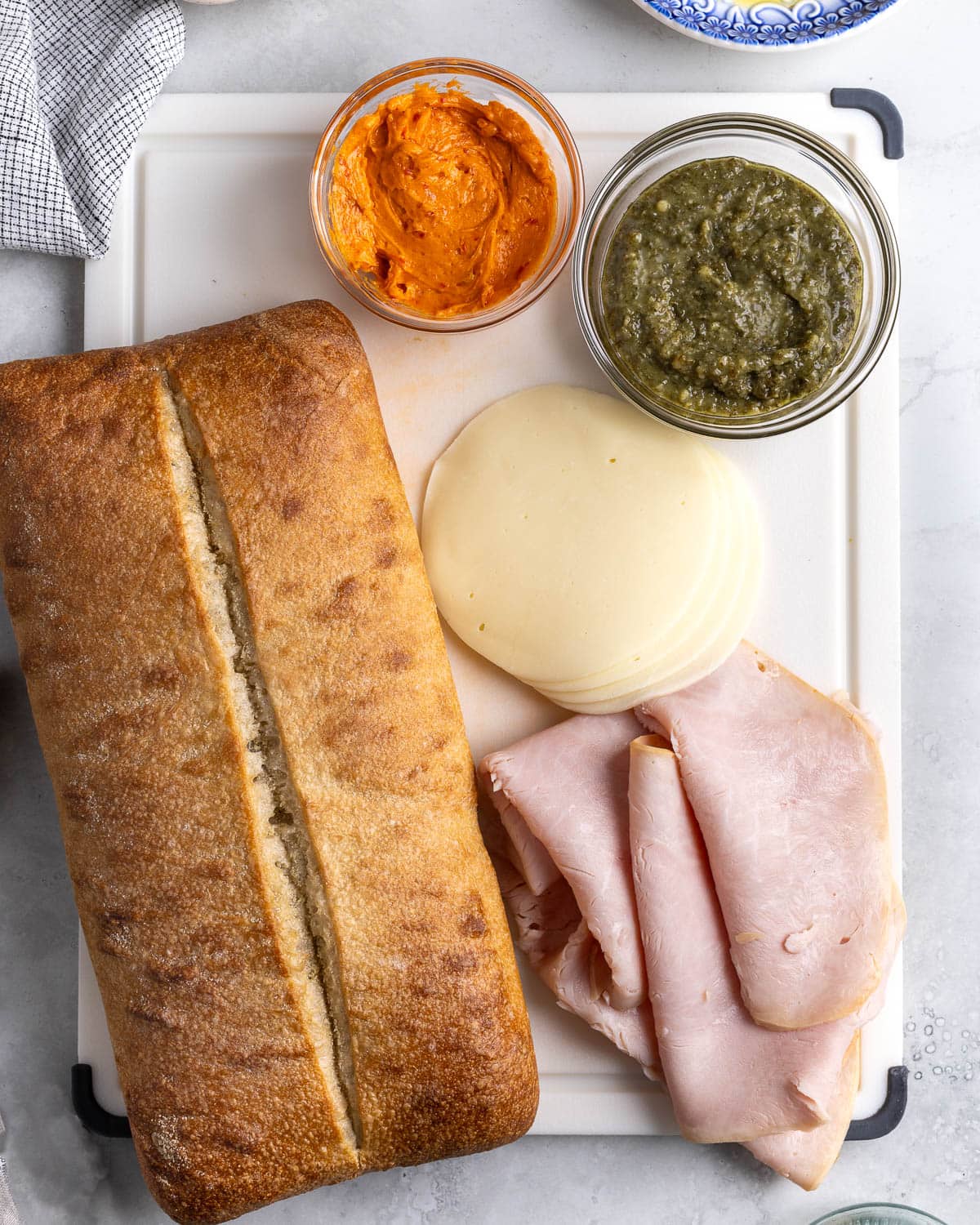 Ciabatta sandwich ingredients on a cutting board.