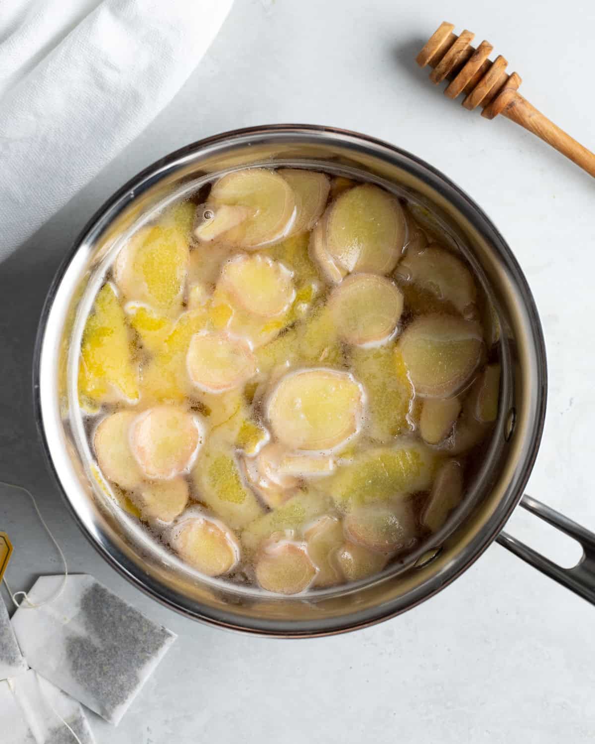 Lemon ginger simple syrup steeping in a pan.