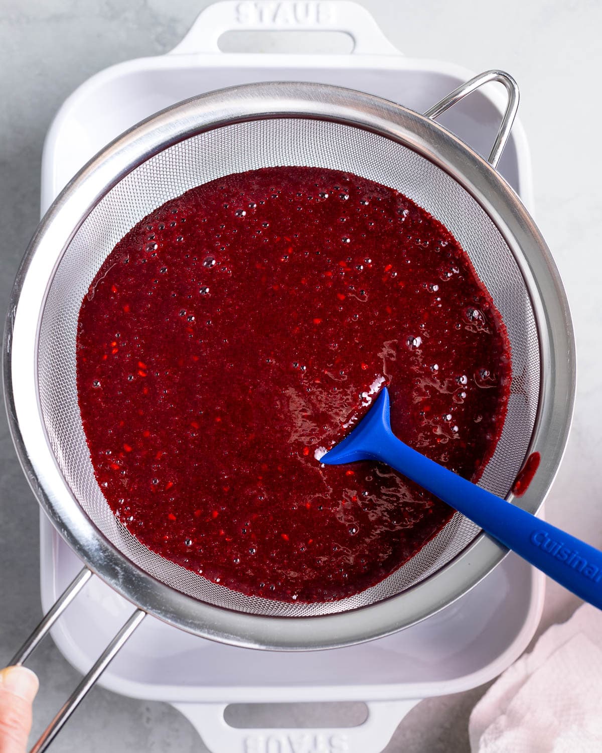 The granita mixture being strained into a rectangular baking dish.