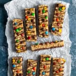 A batch of homemade kudos bars decorated with M&M'S and chocolate drizzle.