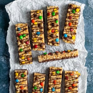 A batch of homemade kudos bars decorated with M&M'S and chocolate drizzle.
