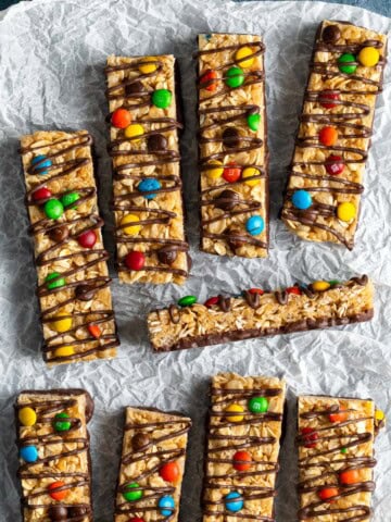 A batch of homemade kudos bars decorated with M&M'S and chocolate drizzle.