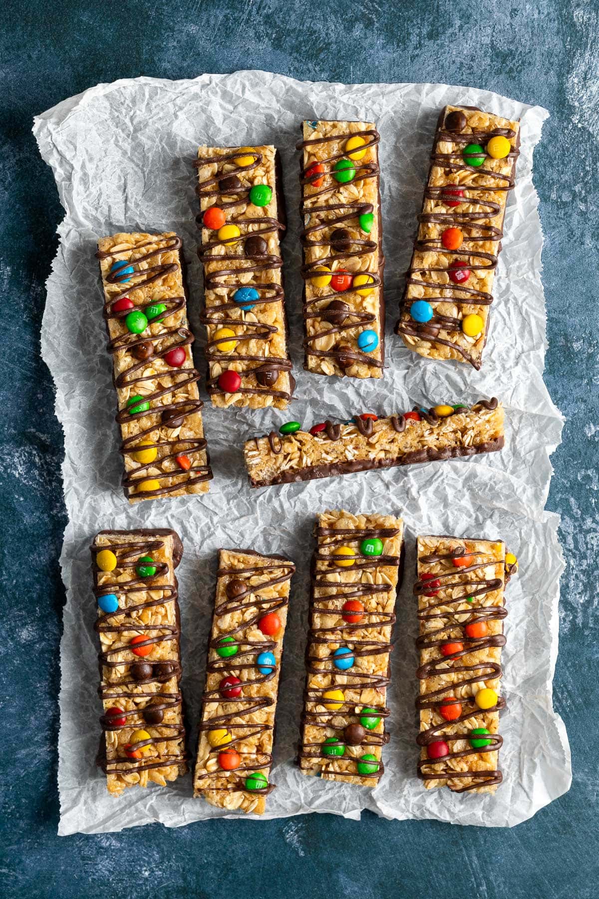 A batch of homemade kudos bars decorated with M&M'S and chocolate drizzle.