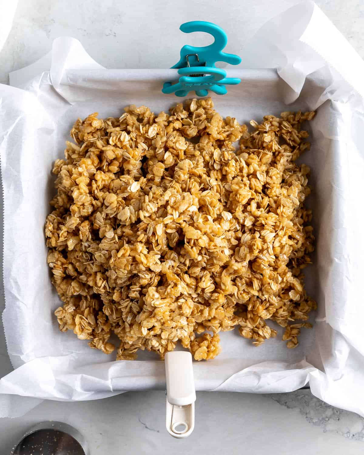 The kudos bar mixture poured out into a parchment-lined square pan.