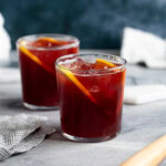 Two full red wine cocktails in short glasses.
