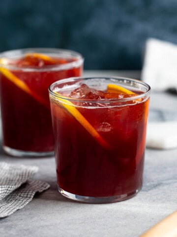 Two full red wine cocktails in short glasses.