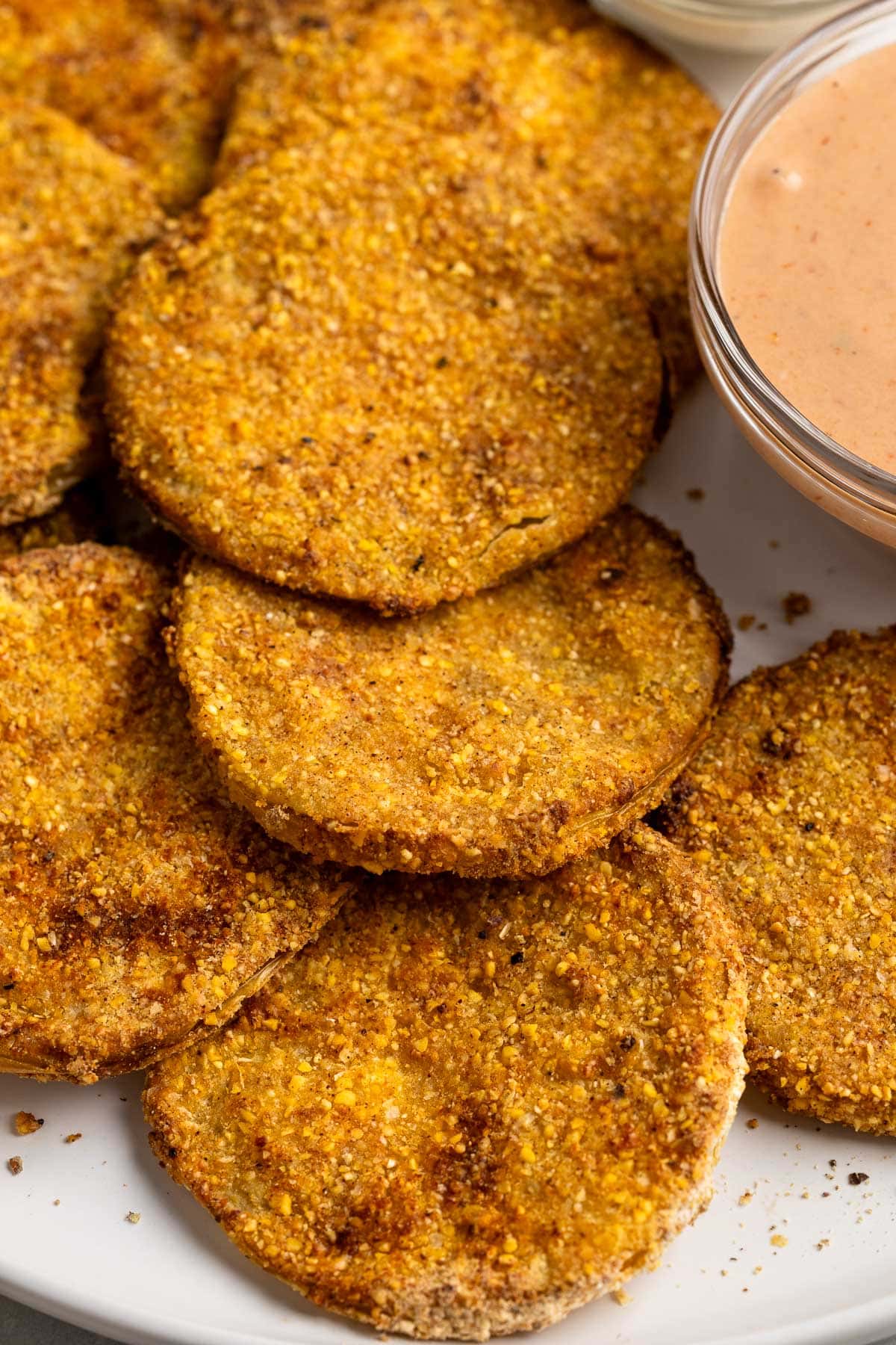 A close-up of air fryer fried green tomatoes on a serving plate.