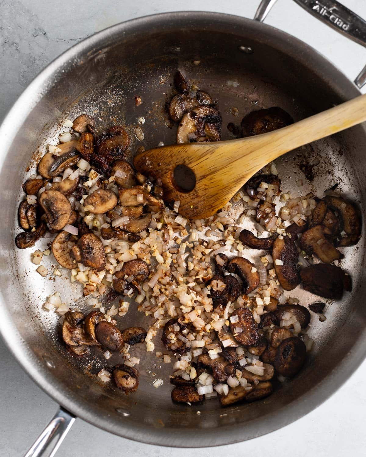 Shallots and garlic added to the pan with mushrooms.