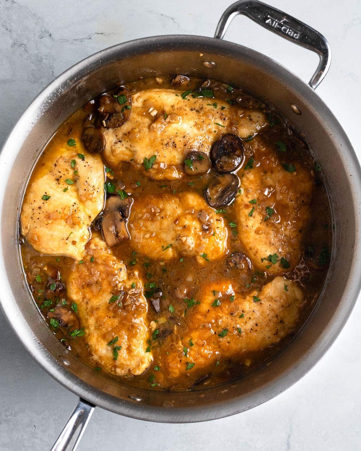 Chicken cutlets added to the pan of marsala sauce ready to serve.