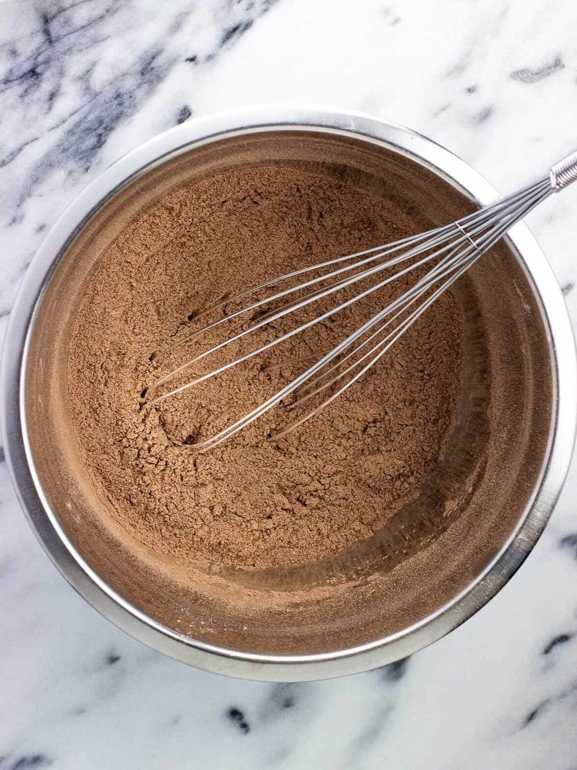 Chocolate yogurt cake dry ingredients whisked together in a bowl.