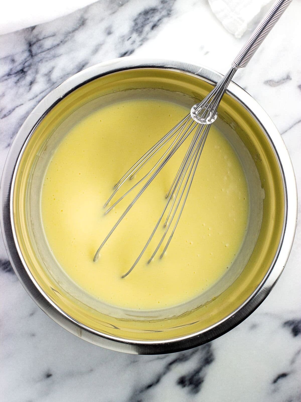The wet ingredients mixed together in a bowl with a whisk.