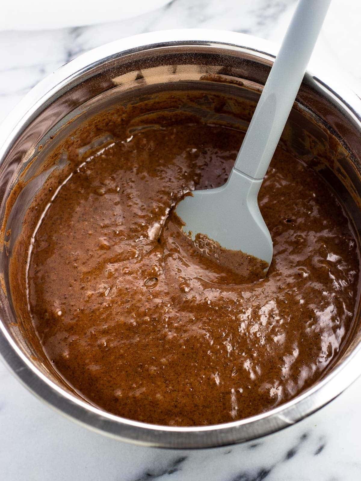 The cake batter mixed together in a bowl with a spatula.