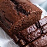 A half-sliced loaf of chocolate yogurt cake.