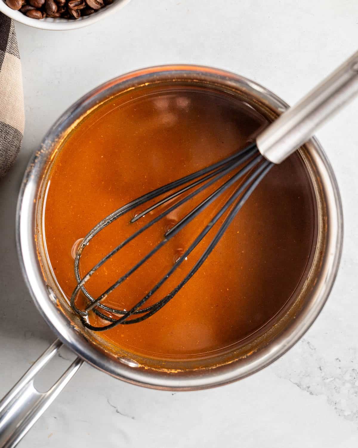 Smooth pumpkin syrup in a pan with a whisk.