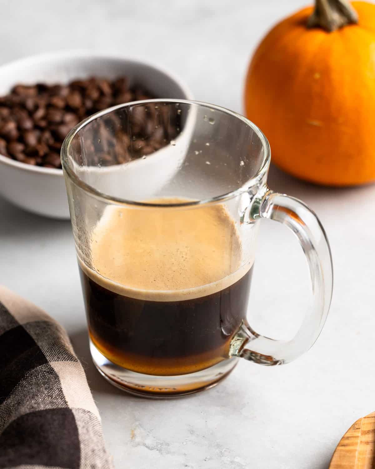 Espresso poured over the syrups in a glass mug.