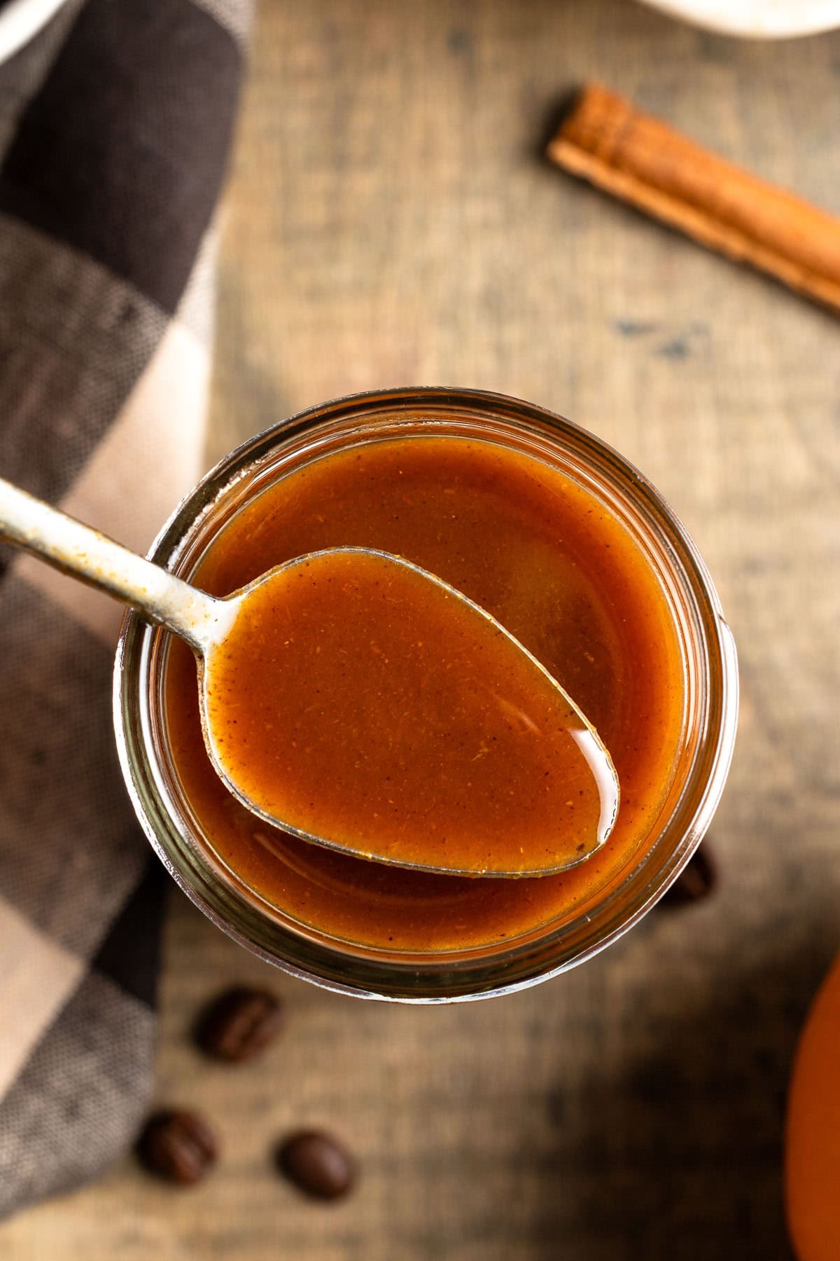A spoonful of maple pumpkin spice syrup being lifted out of the jar.