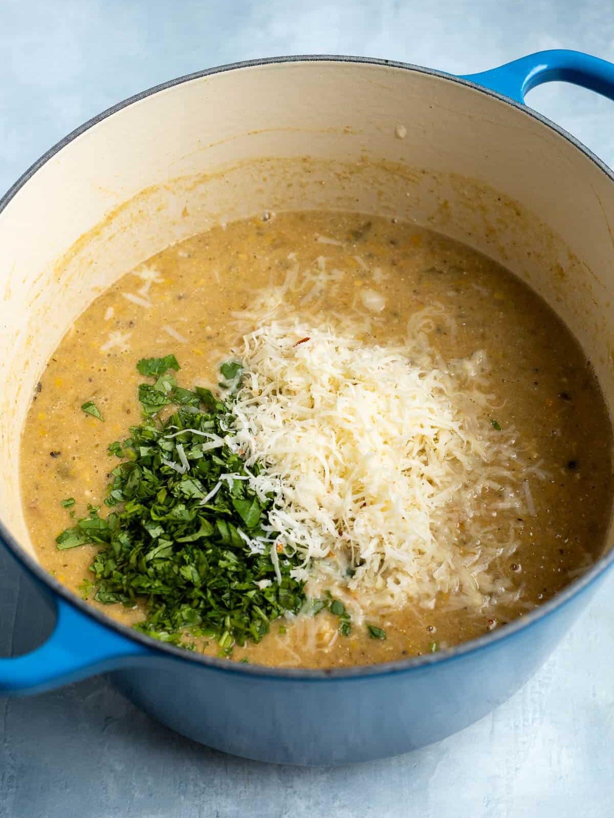 Shredded cheese, lime juice, and cilantro about to be stirred into the chili.