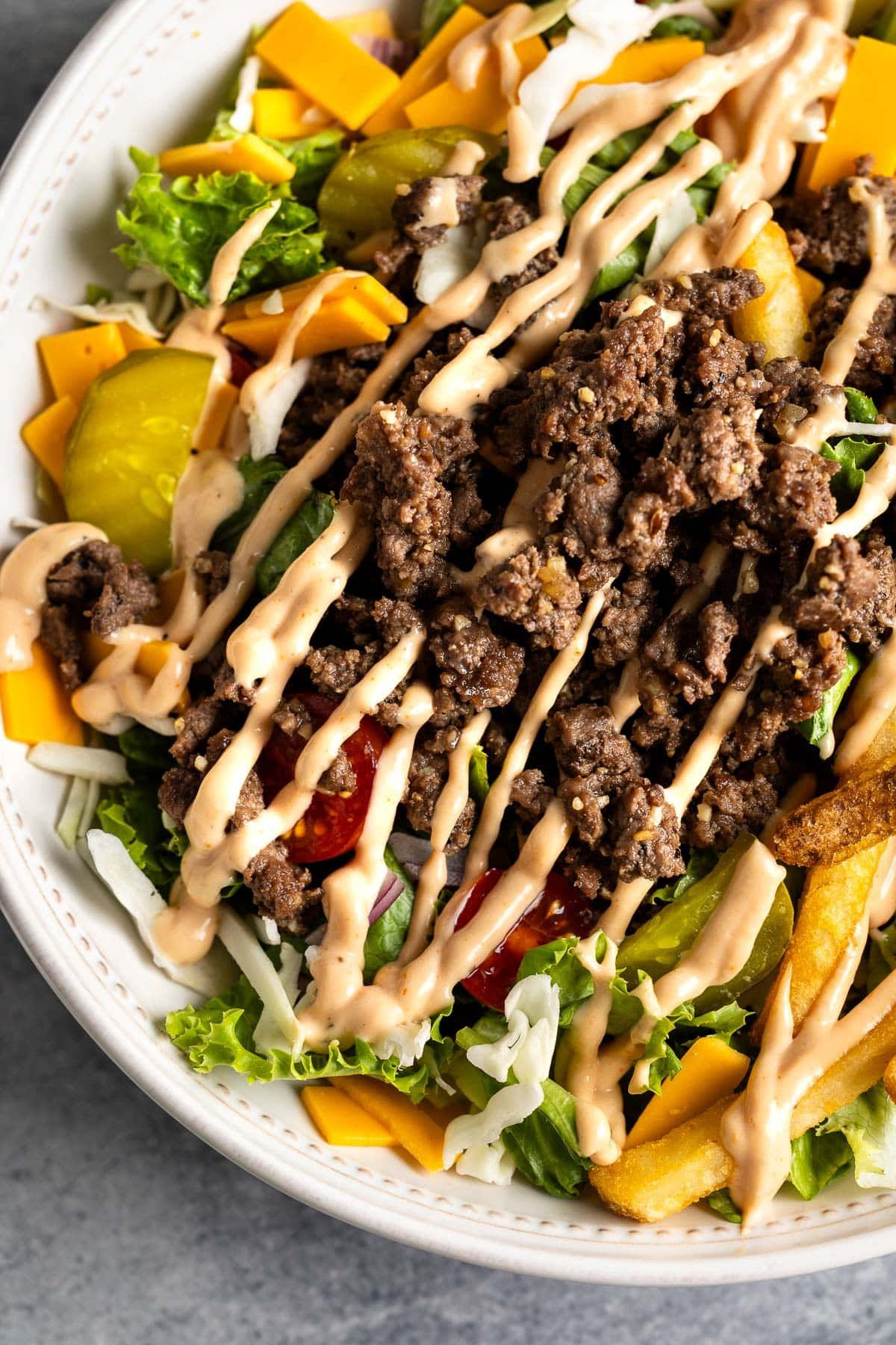 A burger bowl topped with a drizzle of burger sauce.