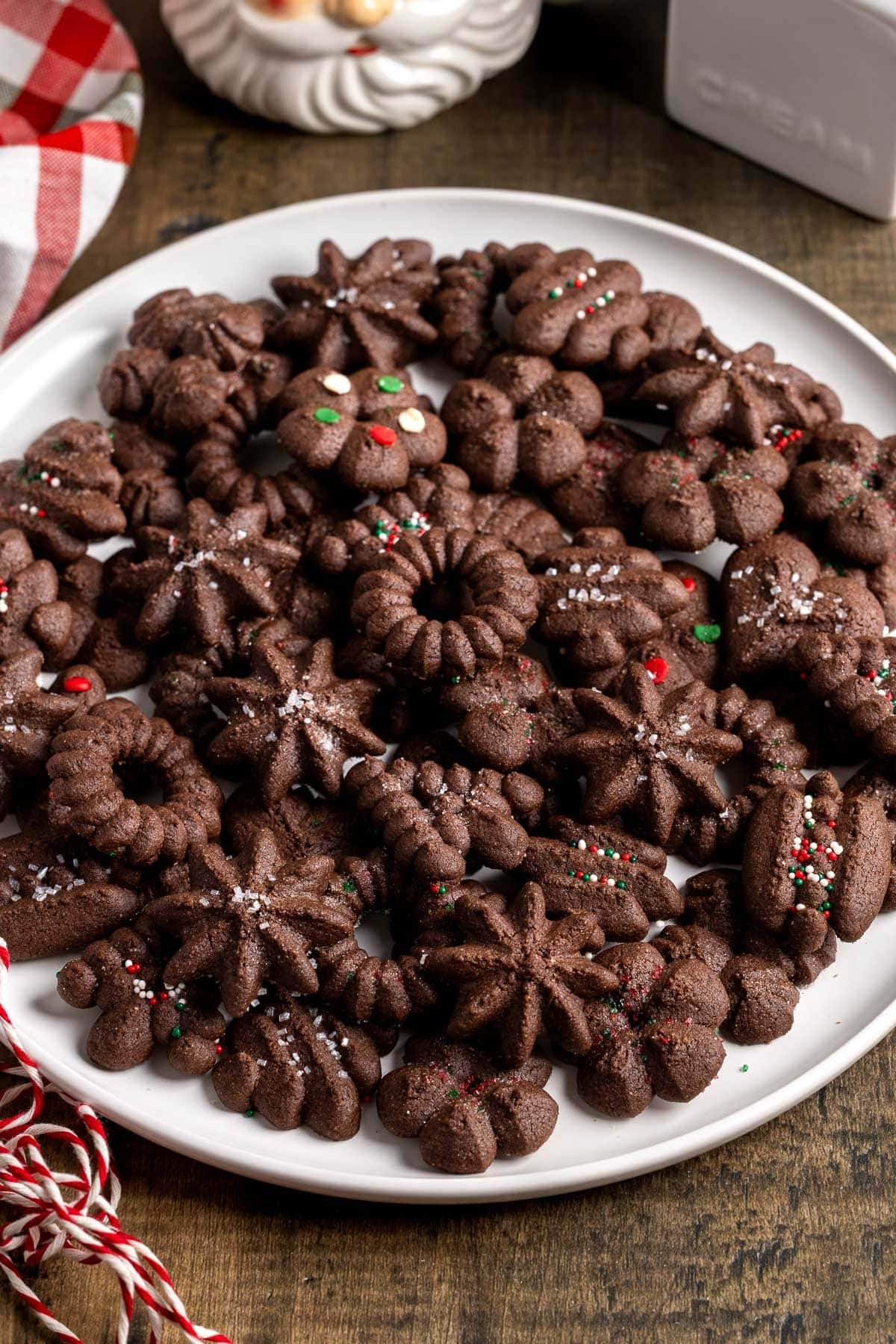 A batch of chocolate spritz cookies on a plate.