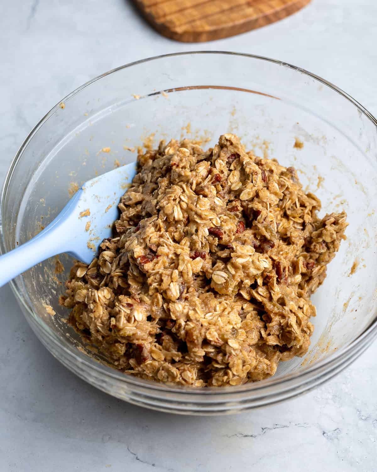 Brown butter oatmeal raisin cookie dough stirred together in a bowl.