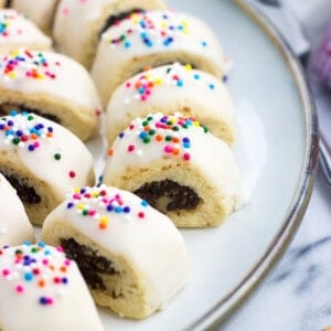 Glazed cucidati lined up next to one another on a serving plate