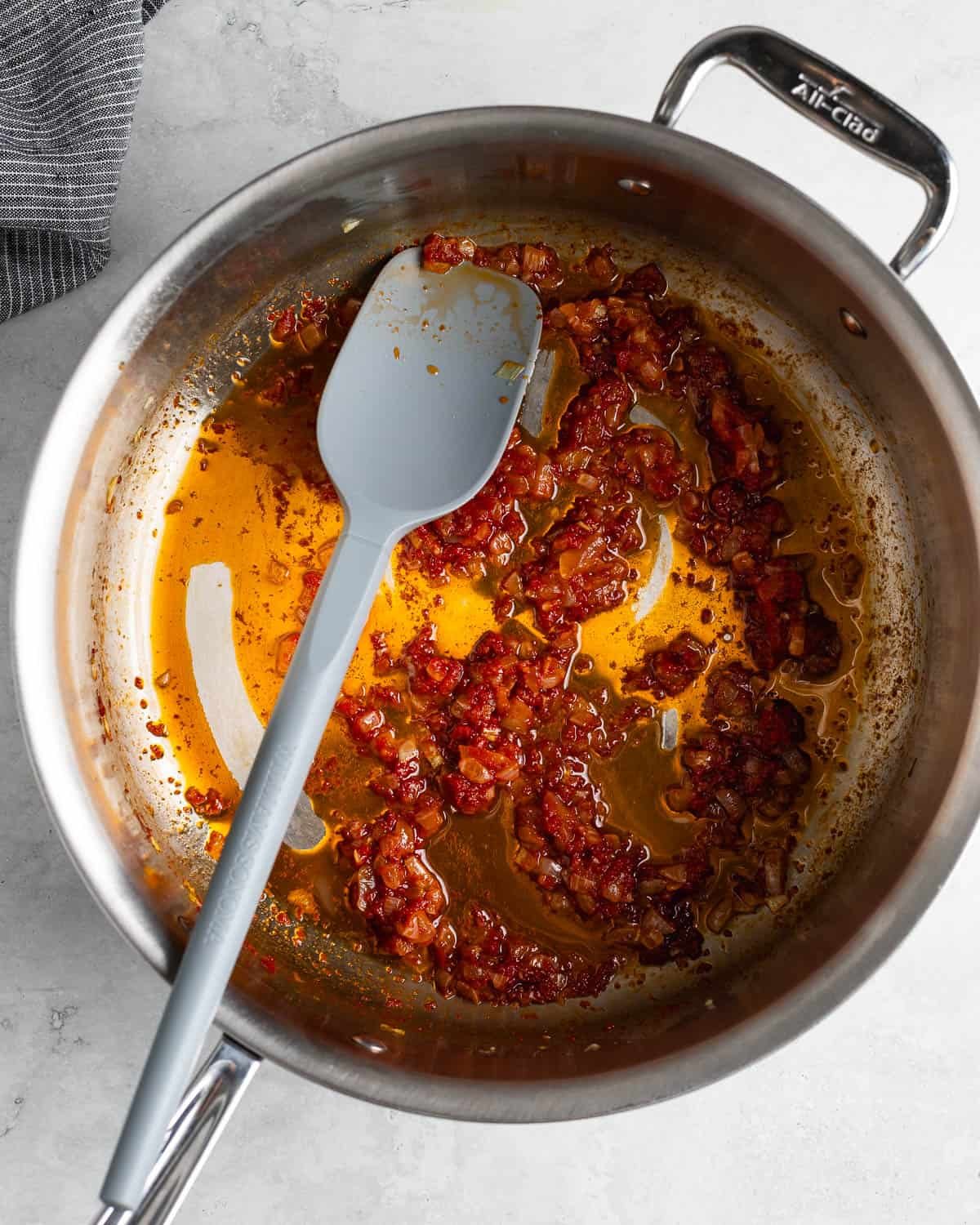 Onion, garlic, and tomato paste sautéed in olive oil in a pan.