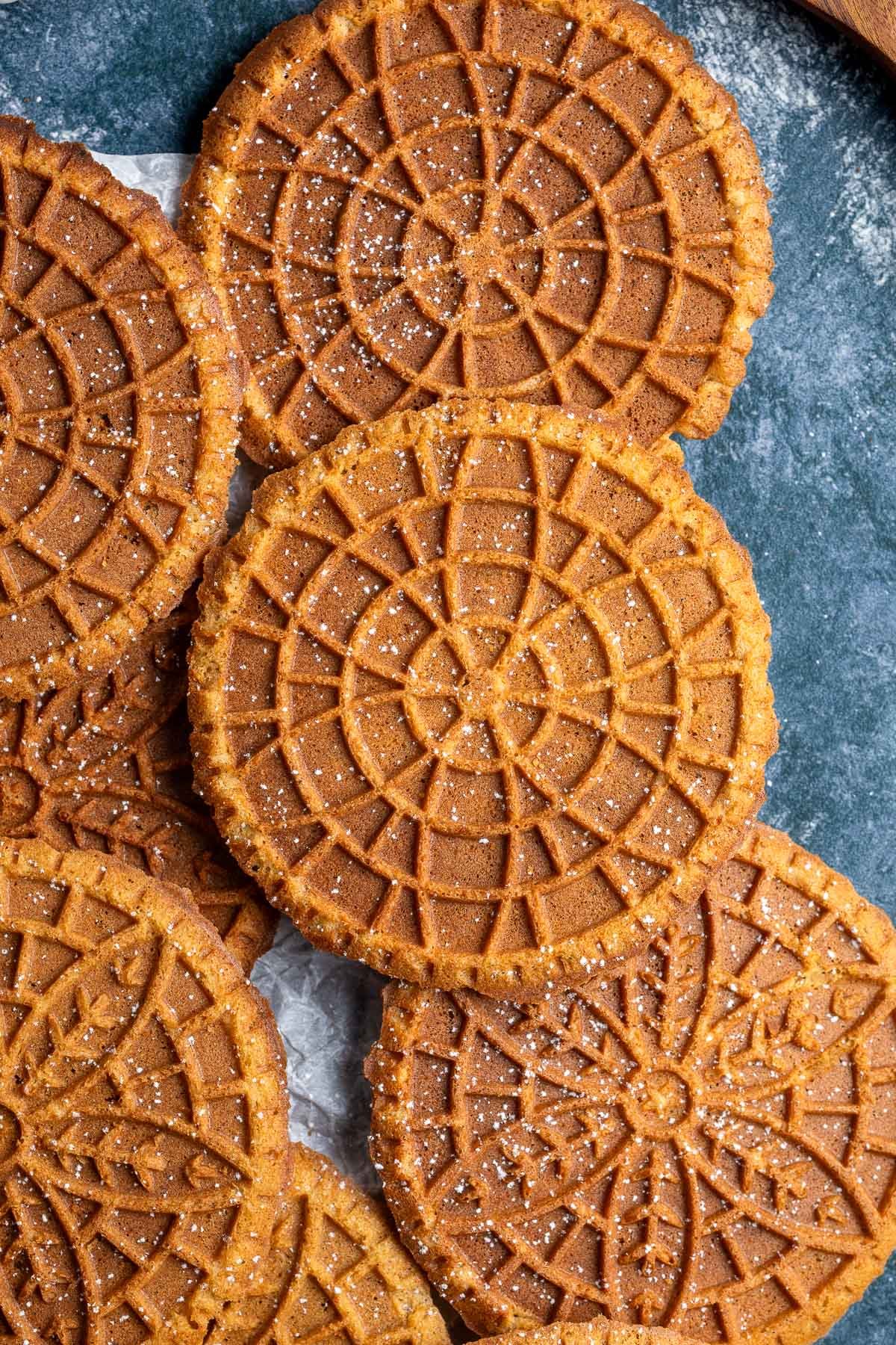 Gingerbread pizzelle dusted with powdered sugar.