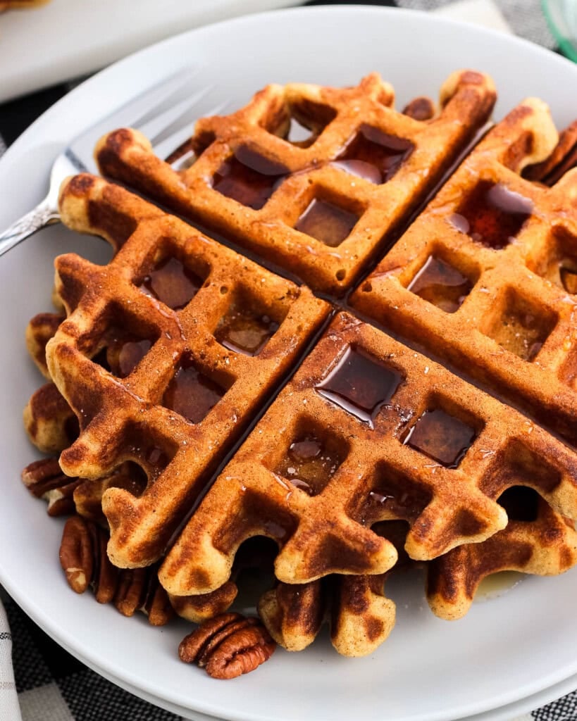 A close-up of a stack of waffles on a plate.