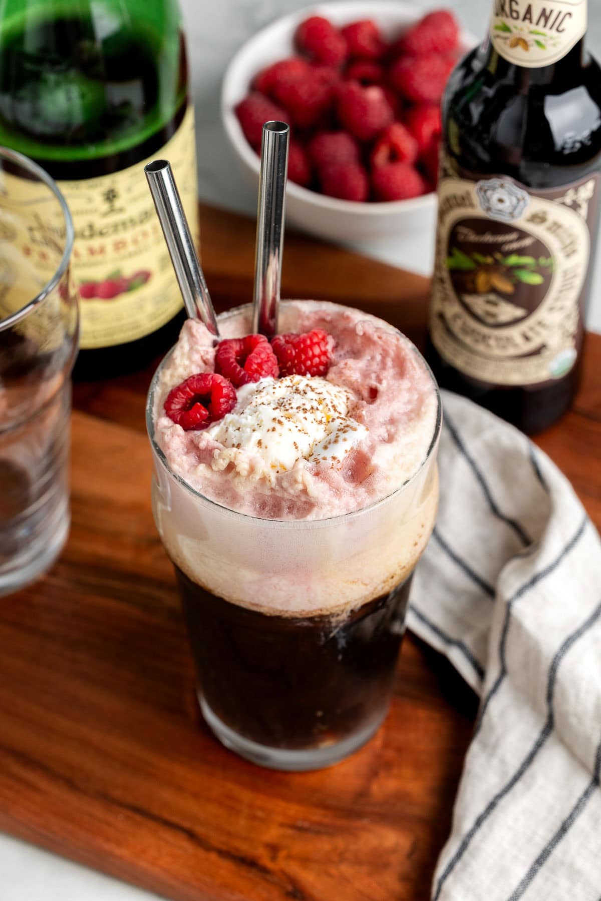 Pink frothy beer float served with fresh raspberries.
