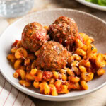 Fiber-rich turkey meatballs served on a plate of pasta and marinara sauce.