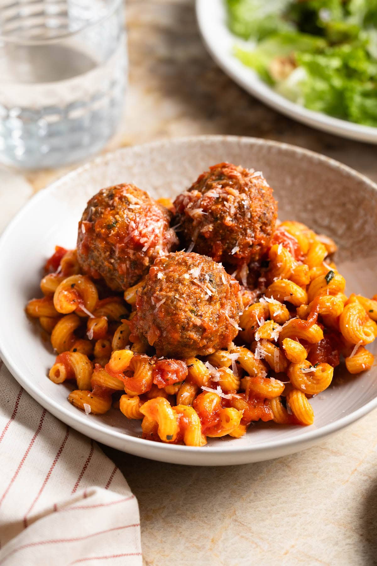 Fiber-rich turkey meatballs served on a plate of pasta and marinara sauce.
