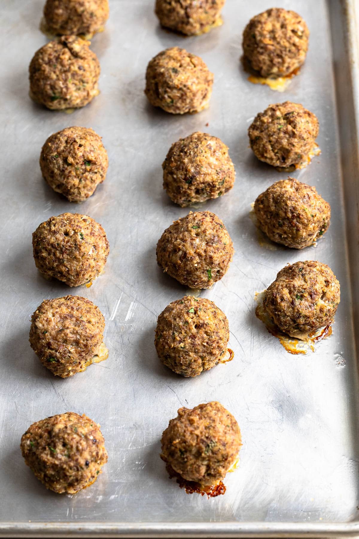Baked turkey meatballs with flaxseed on a sheet pan.